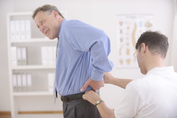 doctor examining patient’s lower back